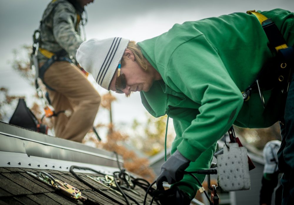 Construction crew installing solar panels on a house